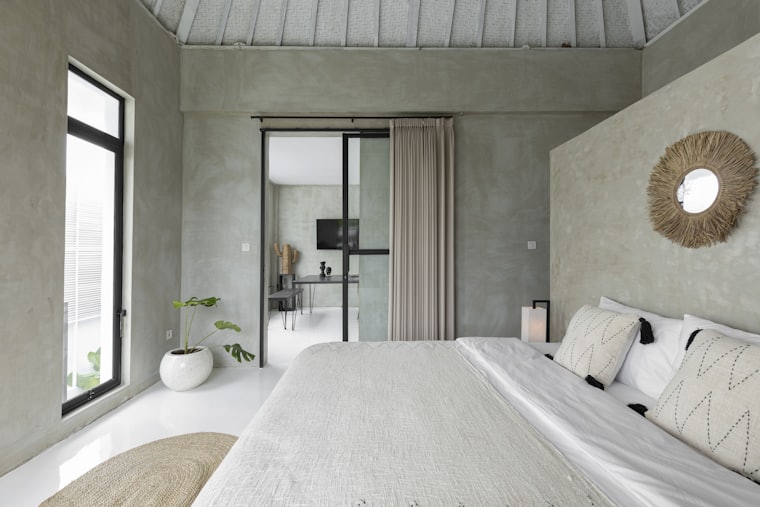 A guest room with morning light through a glass door